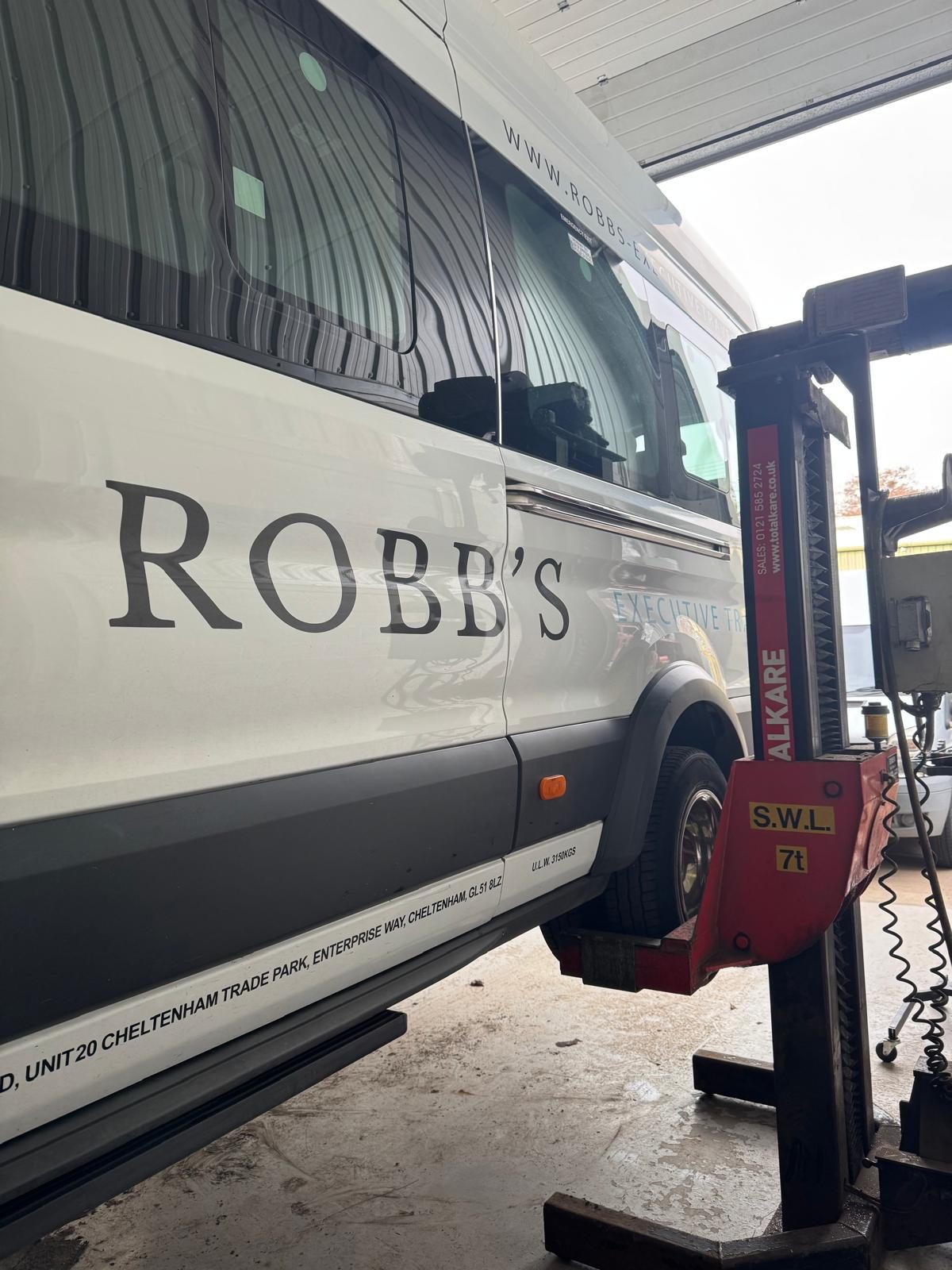 A Robb's vehicle raised on a workshop lift for inspection