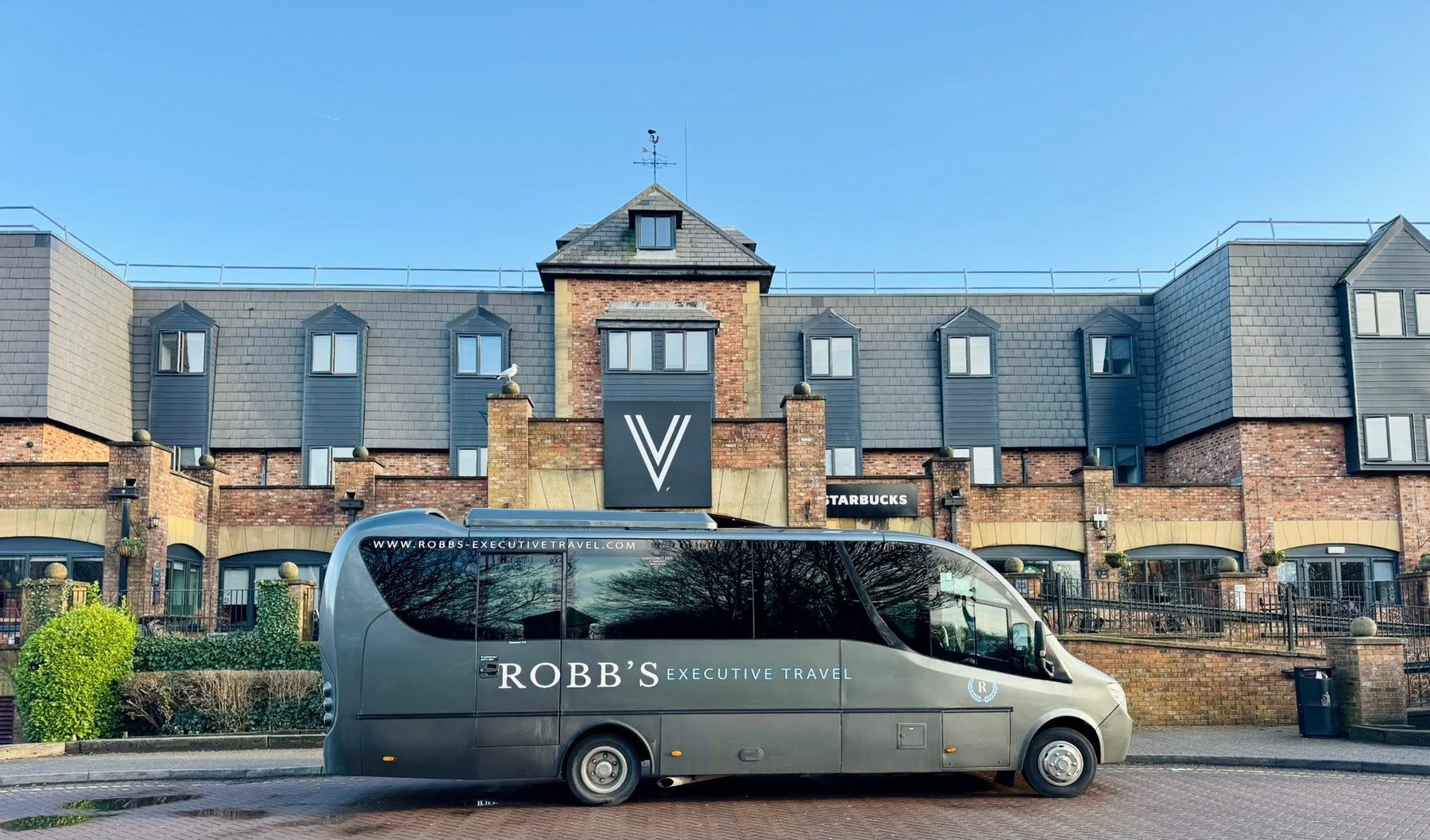 Robb's coach parked outside a hotel for a private hire pickup