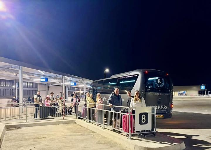 Passengers boarding a Robb's coach at night for an airport transfer