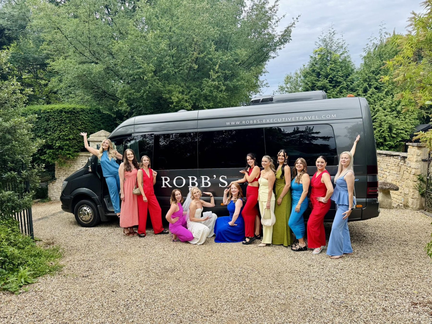 Bridal party posing in front of a Robb's minibus